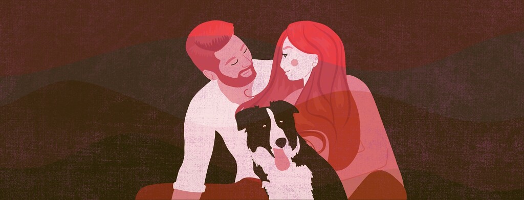 A man, woman and dog sit happily together