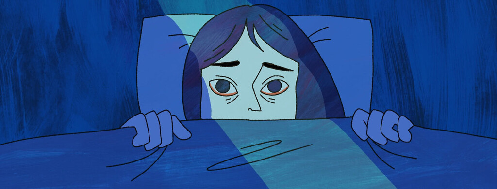 A woman laying awake in bed.